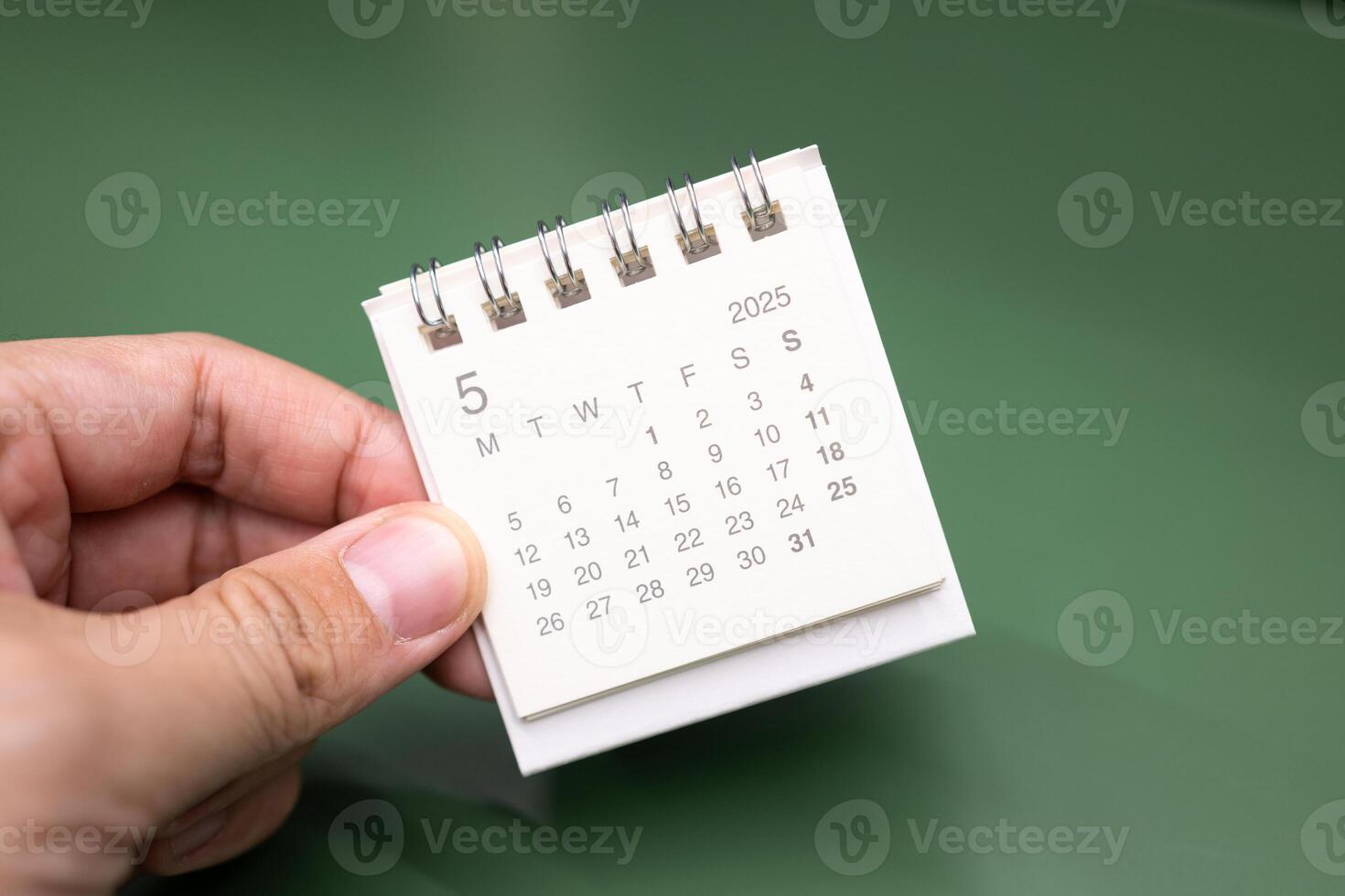 Hand holding mini calendar for MAY 2025 background. Calendar concept with 2025 MAY calendar. photo