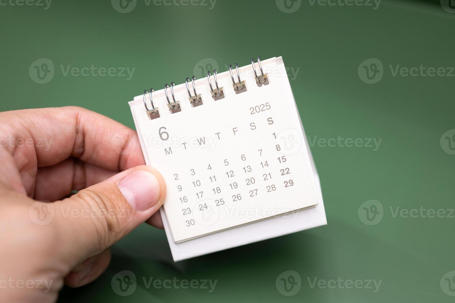 Hand holding mini calendar for 2025 JUNE background. Calendar concept with 2025 JUN calendar. photo