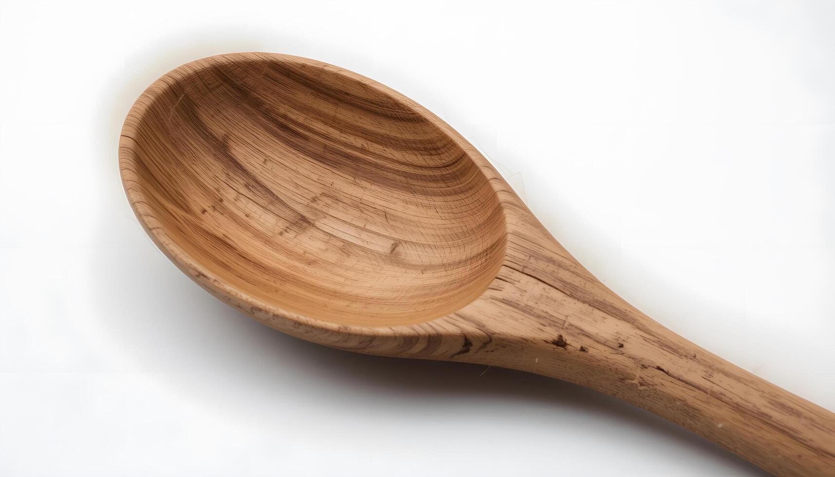 Close-up of a rustic wooden spoon isolated on a white background. photo