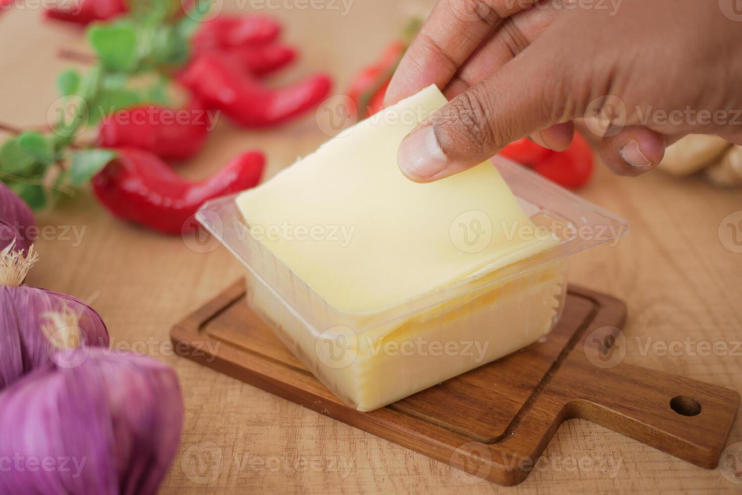 Fresh Slice of Cheese with Vegetables on Wooden Table photo