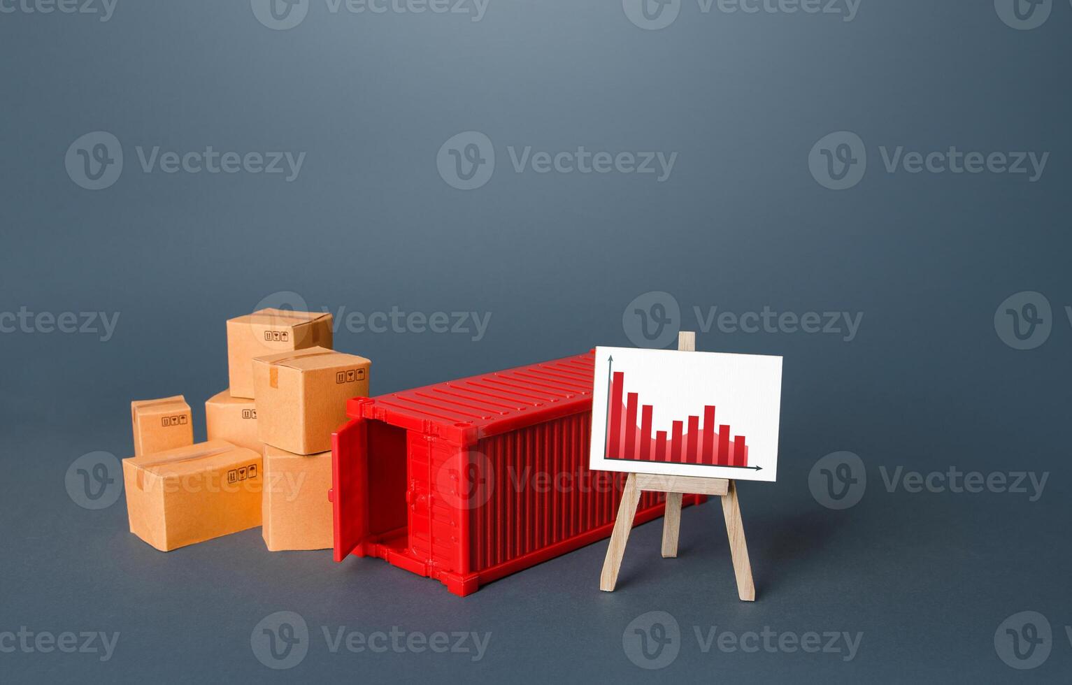 Boxes and container near the easel with falling graph. Drop of transportation volume, world trade traffic reduction. Fall in sales. Reduced prices for freight and transportation of goods. photo