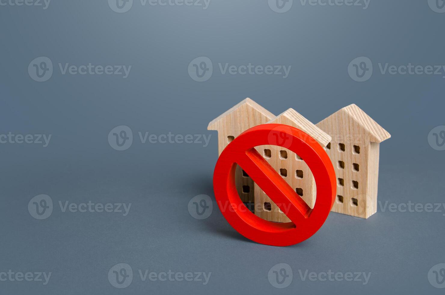 Residential buildings and red prohibition symbol No. Restrictions ban on construction. Inaccessible expensive housing. Restriction building compaction. Underdeveloped infrastructure utilities photo