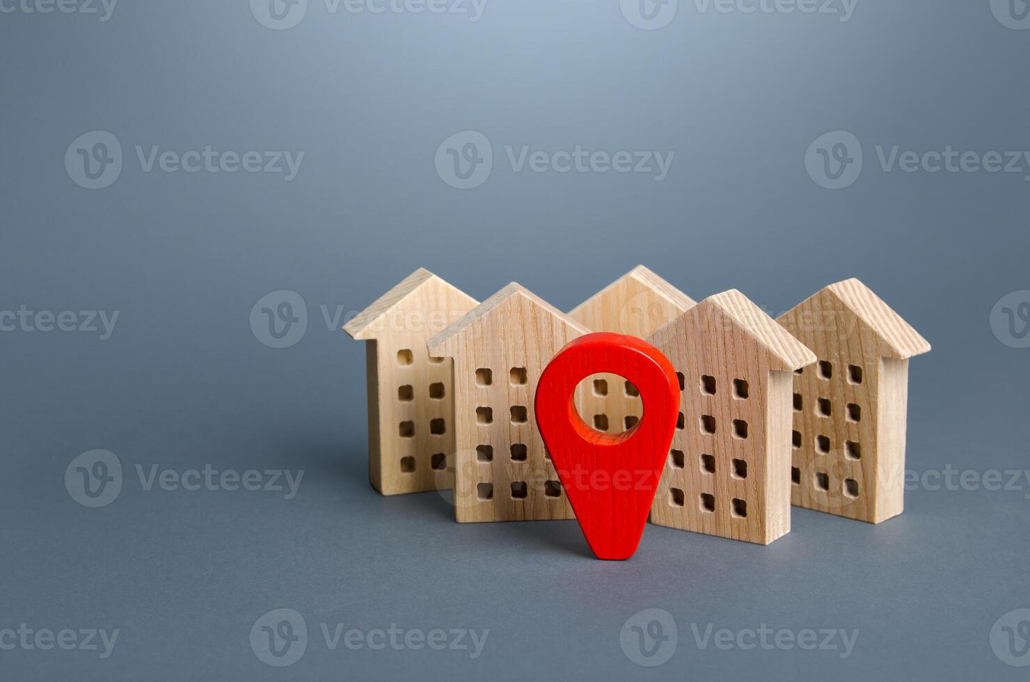 Wooden houses and a red location pin. Location, accessibility and proximity to infrastructure. Residential complex. City navigation, orienteering. Visit the town. Search for housing options photo