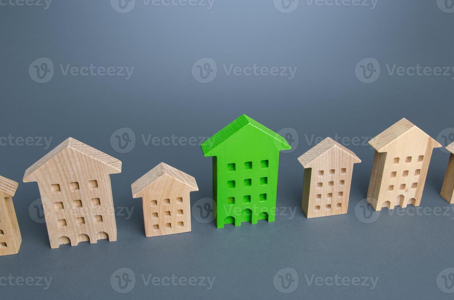 Green residential building among houses. Environmentally friendly, energy efficient and zero carbon emissions. Search for the best option to buy an apartment. Net Zero Carbon neutrality. High quality photo