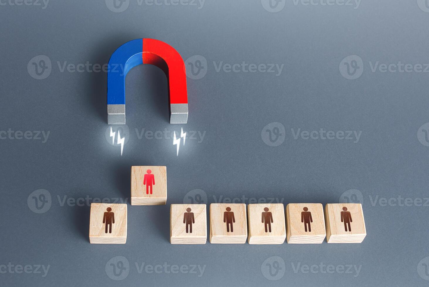 The magnet selects one person from the row. Finding the best recruiting candidate. Hiring and staffing. Human resources. Search for the right person. Poaching an employee to your company. Luring photo
