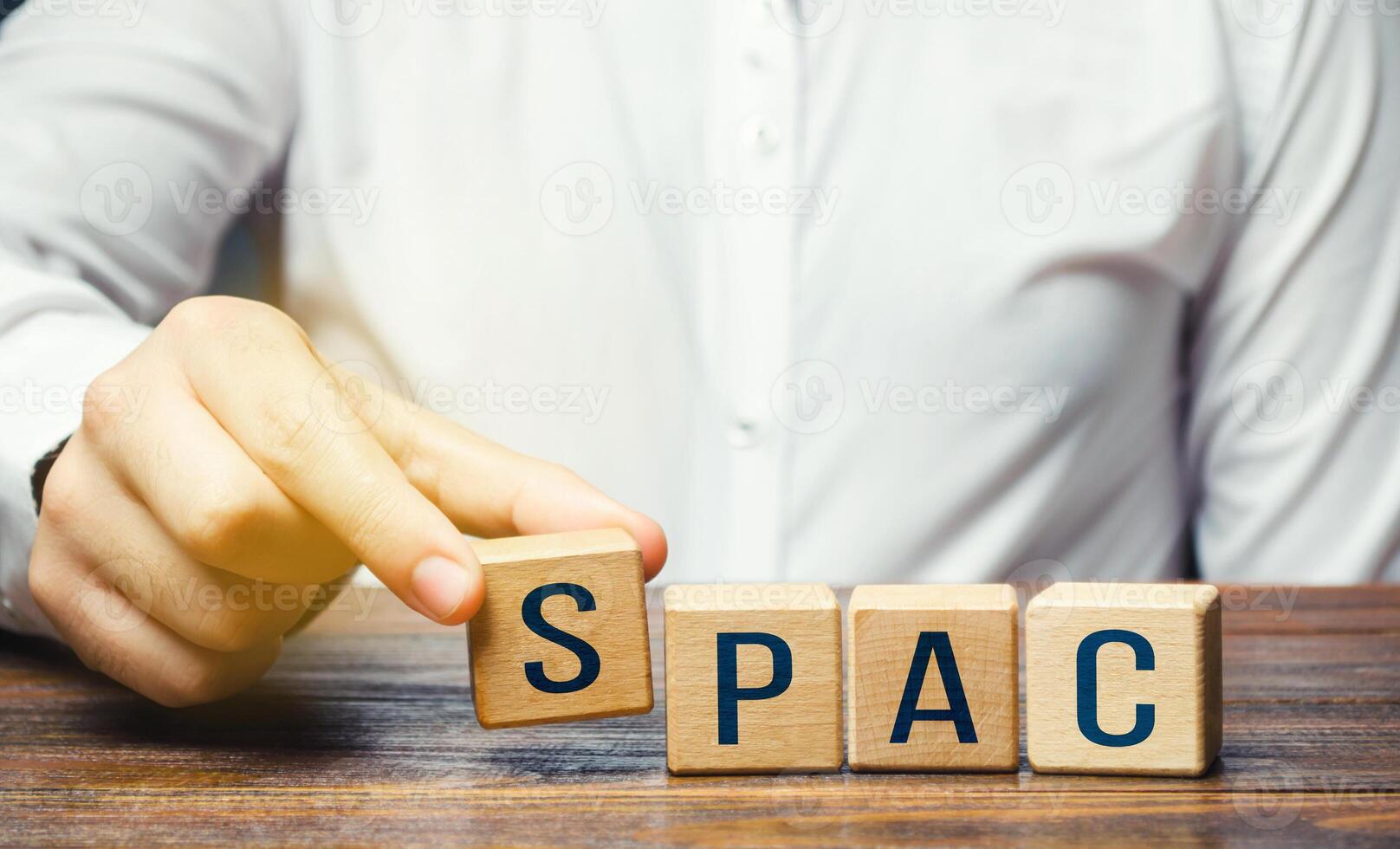 Man making SPAC word from blocks. in a row. A easy way stock exchange financial instrument for attracting investments. Development of new simplified procedures for attracting business investment. photo