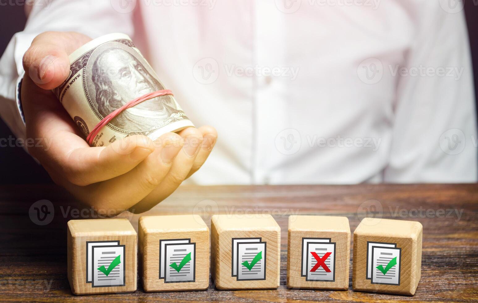 Man holds money above of blocks with permits documents. Artificial bureaucratic obstacles, corruption risks, non-transparent legislation. Bribe to obtain missing permits. Contract terms violation photo