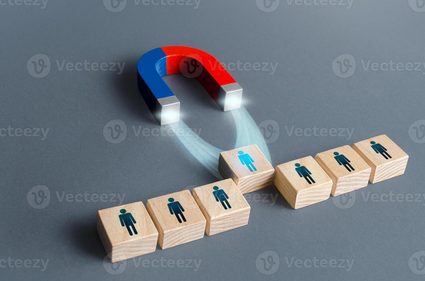 Magnet pulls a person out of row blocks. Choosing best candidate for hiring. Competition for a working high position of a manager. Poaching participants from other company team. Luring concept photo