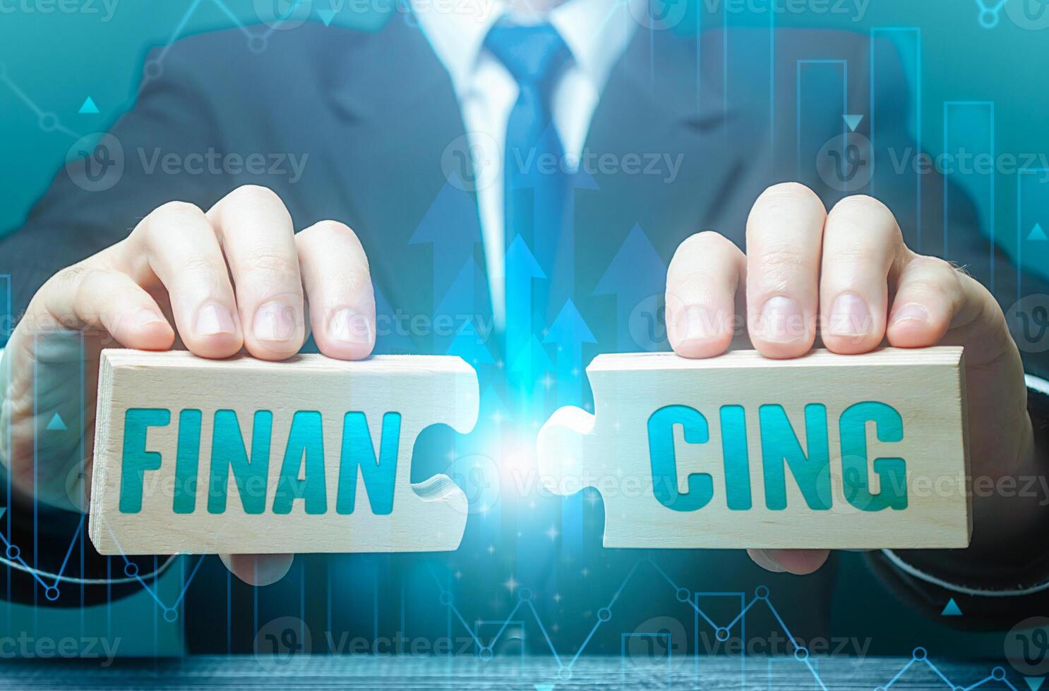 Businessman connects puzzles with the word financing. Investing in a business project, raising funds. Credit, donations, taxes, support grants, savings and subsidies. Financing from the budget. photo