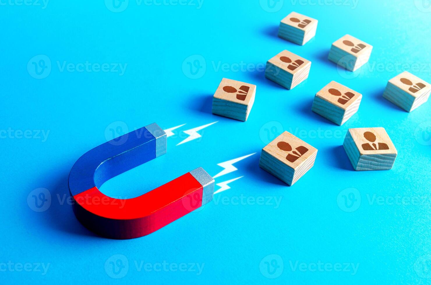 Magnet attracts blocks to people. Recruiting new workers. Search for specialists and professionals. Brain drain to developed countries through educational grants. Business team building. Hiring photo