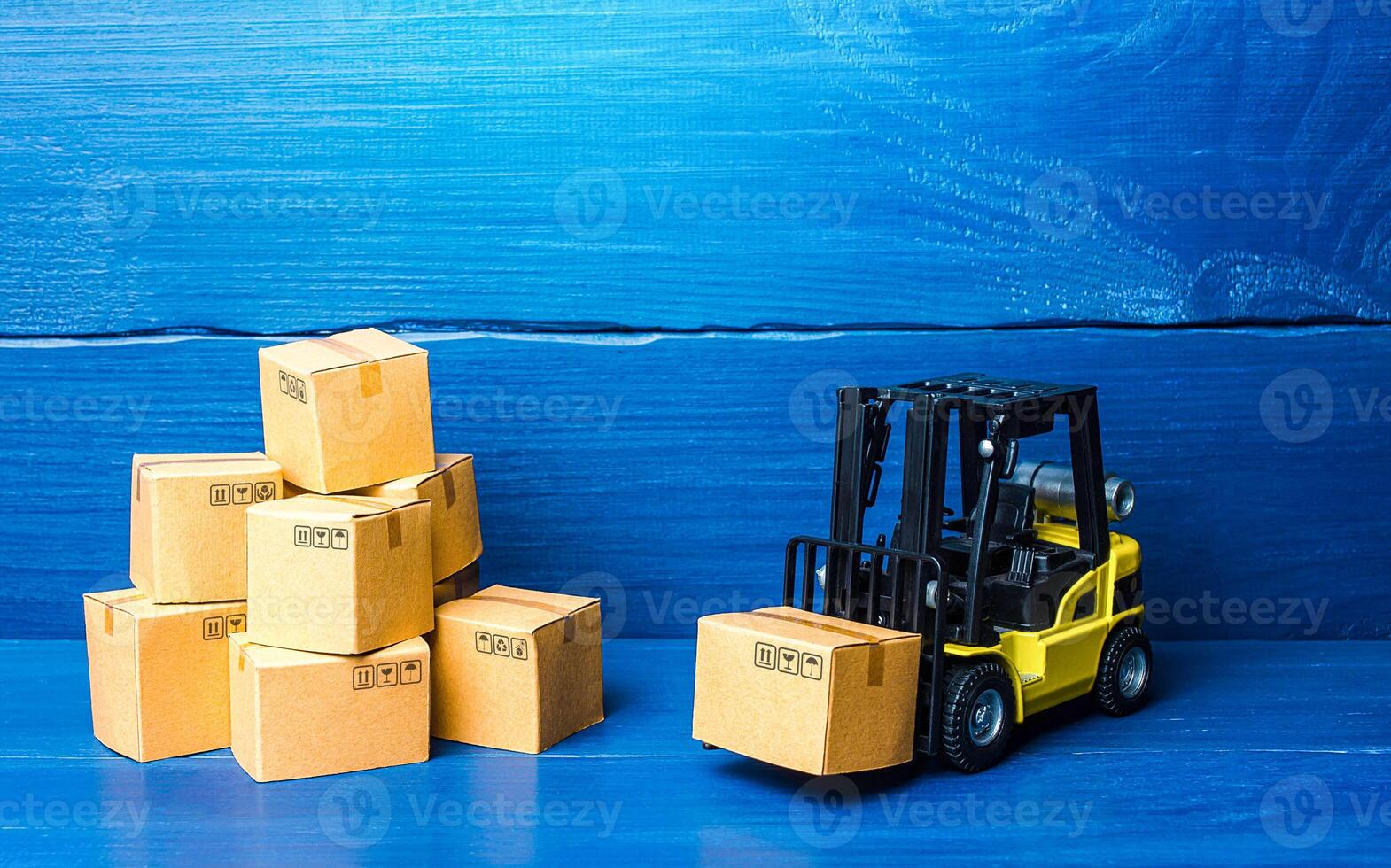Forklift truck and cardboard boxes with goods. Logistic infrastructure and warehousing services. Transportation transfer industry. Warehouse technologies. Improving low cost efficiency delivery speed. photo