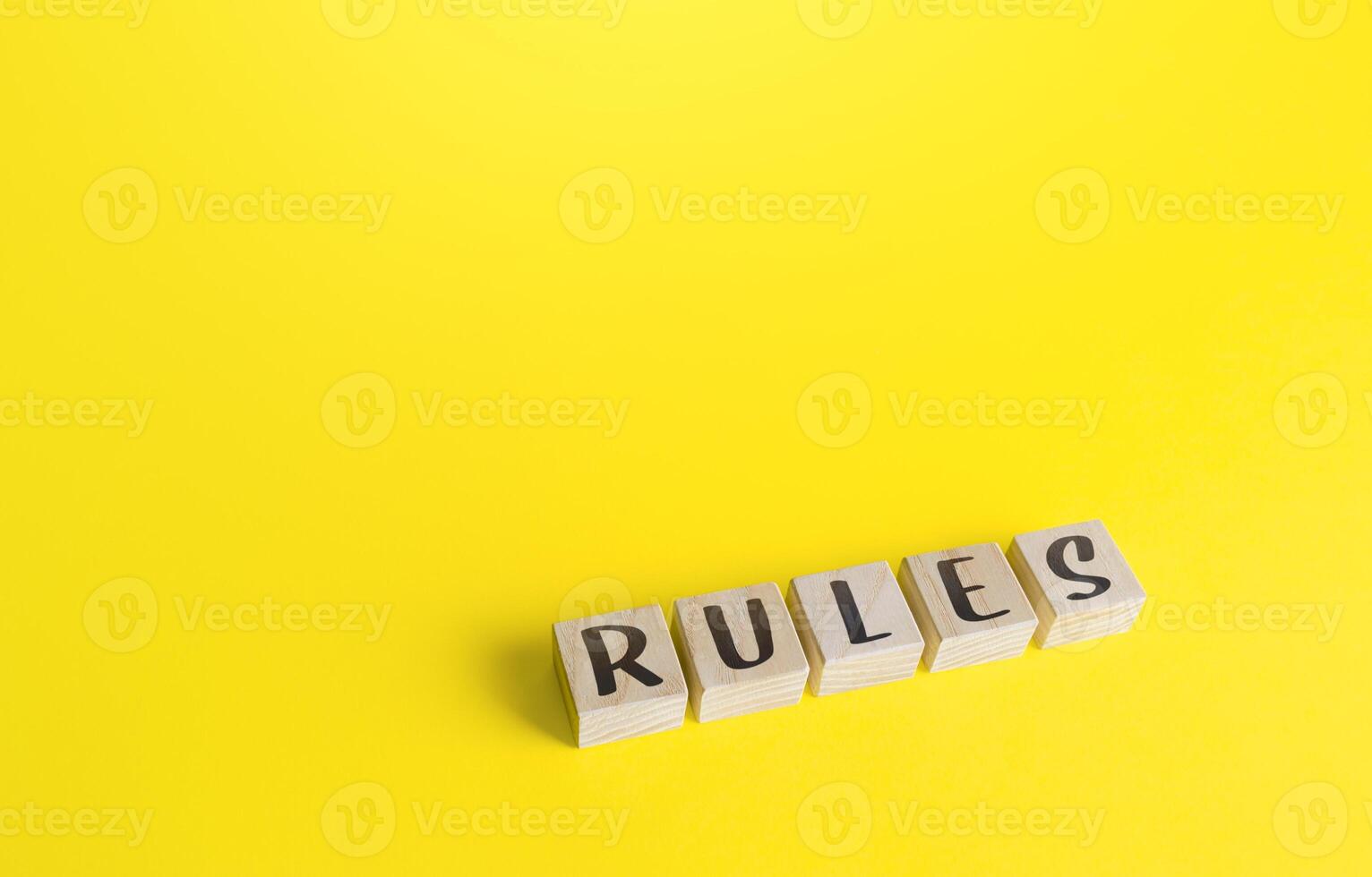 Blocks with the word Rules on yellow background. Laws and community ethics norms. Terms of the contract and the obligations of the parties. Control and monitoring, standardization. Order, discipline. photo