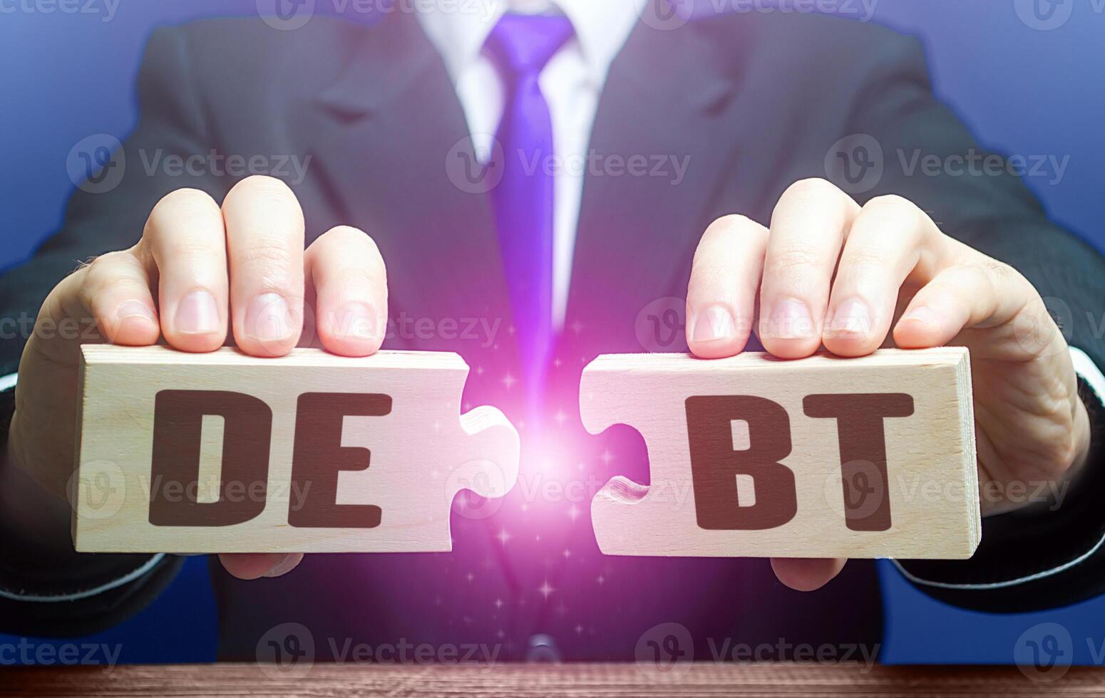 Man breaks puzzles with word Debts. Debt restructuring. Financial distress. Refinancing loan workouts. Challenging the legality of debt collection and writing off penalties. Deferment of payment photo