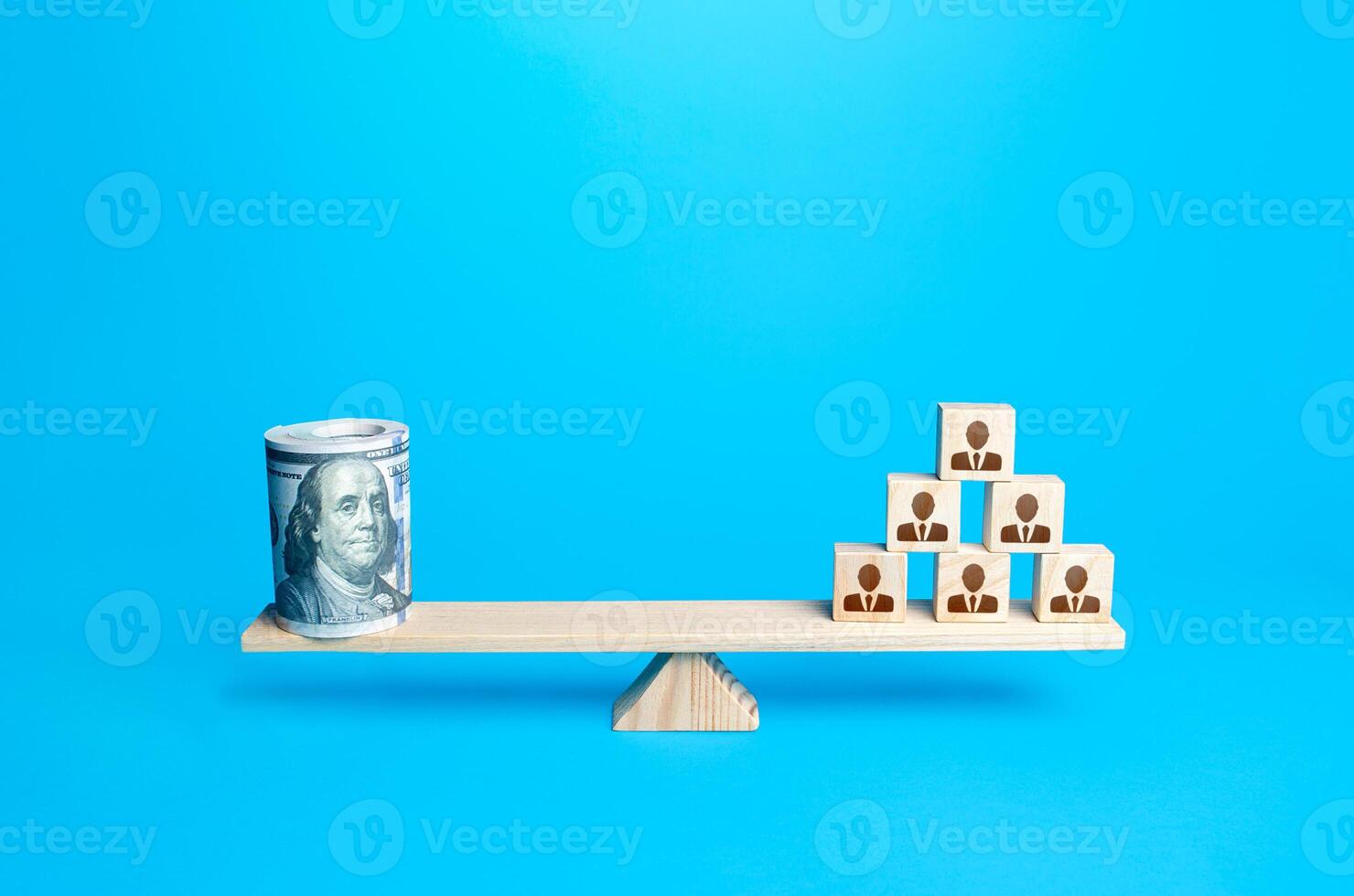 People blocks pyramid and rolled up bundle of dollars on scales. Financing the company and remuneration of staff. Organization accounting. Investments in human capital. Tax collection. Salary fund. photo