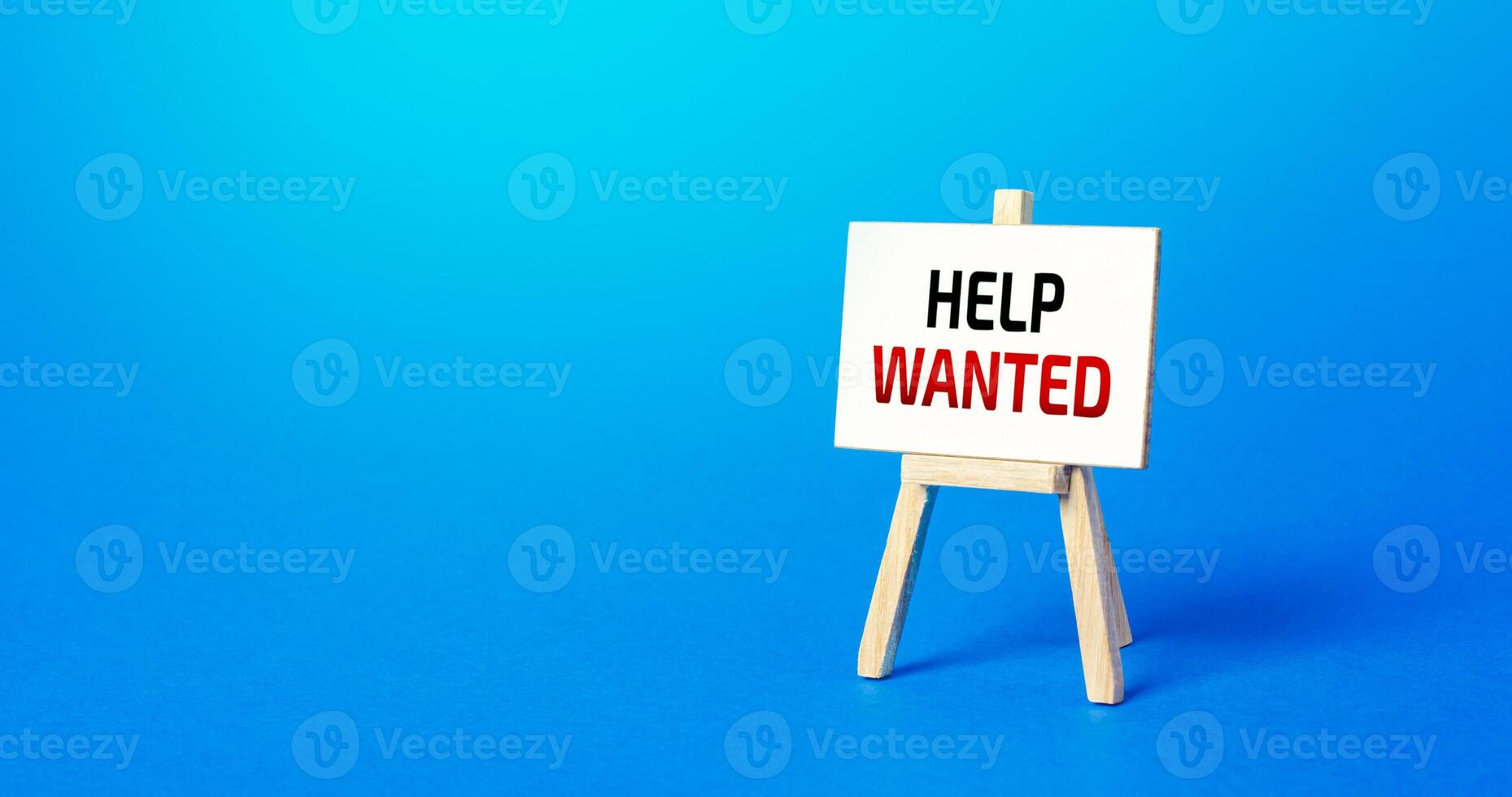 Easel with the words Help Wanted. Call for help, volunteering. Search and recruitment of new employees for work. Providing support. Drawing attention to a social problem. Advertising. Staff expansion photo