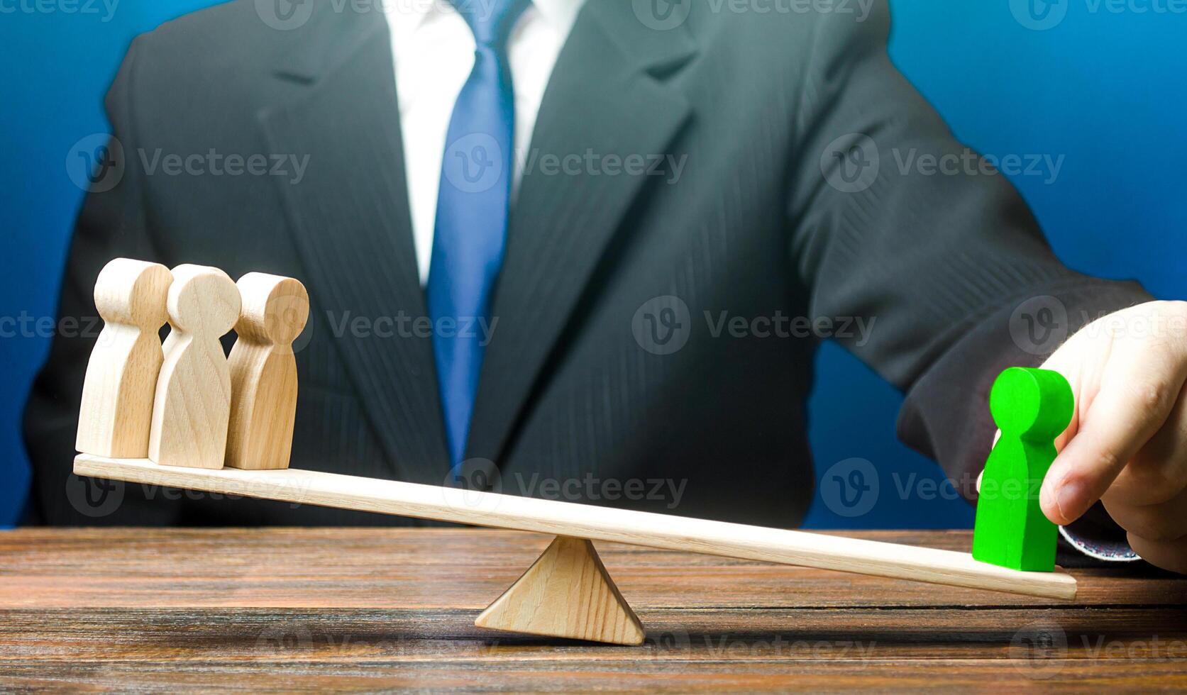 Man opposes green man to group of people on scales. Appointment of a leader. A talented employee is more productive. Set as an example. Give a head start. Career growth, nepotism. Inequality of rights photo