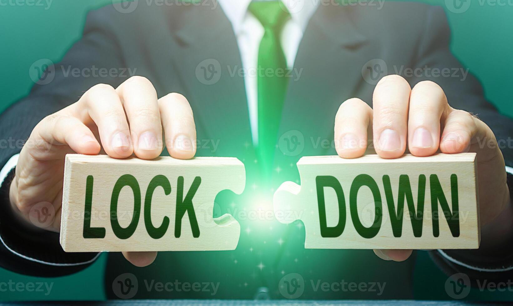 A man breaks apart puzzles with the word Lockdown. The end of the period of strict quarantine measures. Resumption of the work of commerce and trade. Support economy. New normal. Easing prohibitions photo