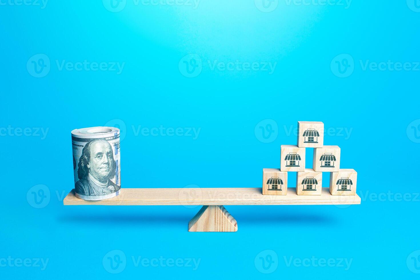 Blocks with symbols of business shops and a bundle of money dollars on scales. Franchising. Assessing value of a business empire. Calculation of income and taxes. Rent commercial property photo