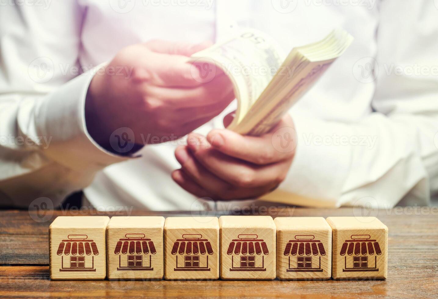 Blocks symbolizing business network and businessman counting money. Building a successful business empire. Expansion and competitive growth. Franchise concession concept. High return on investment. photo