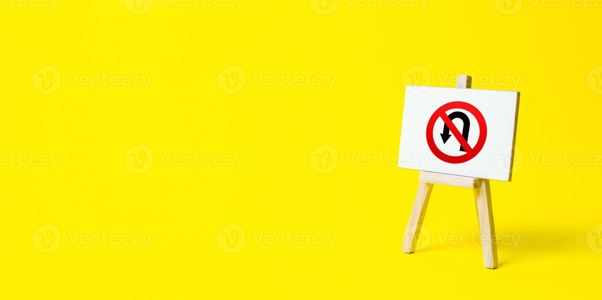 Easel with no turning back traffic sign on a yellow background. Assertiveness and striving, moving forward without retreating. Go to the goal, don't stop. Finish things. There is no way back. photo