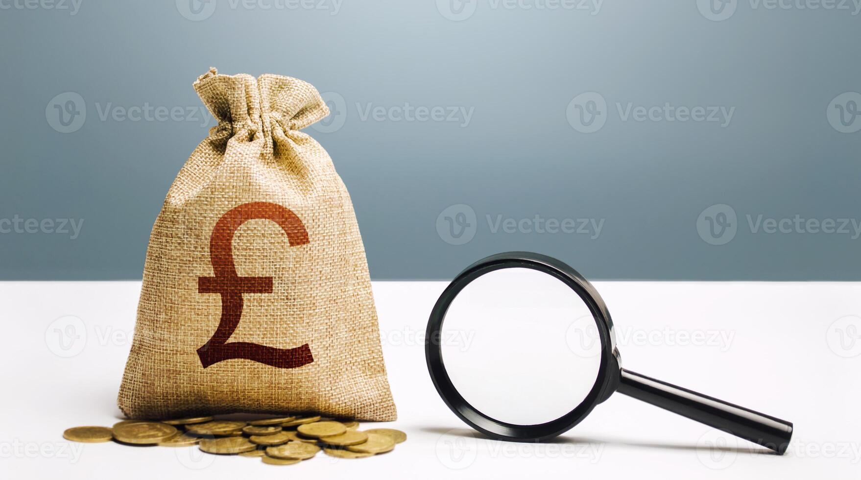 British pound sterling money bag and magnifying glass. Financial audit and monitoring of suspicious capital and transactions. Budget check. Attracting investments financing. Search for beneficiaries. photo