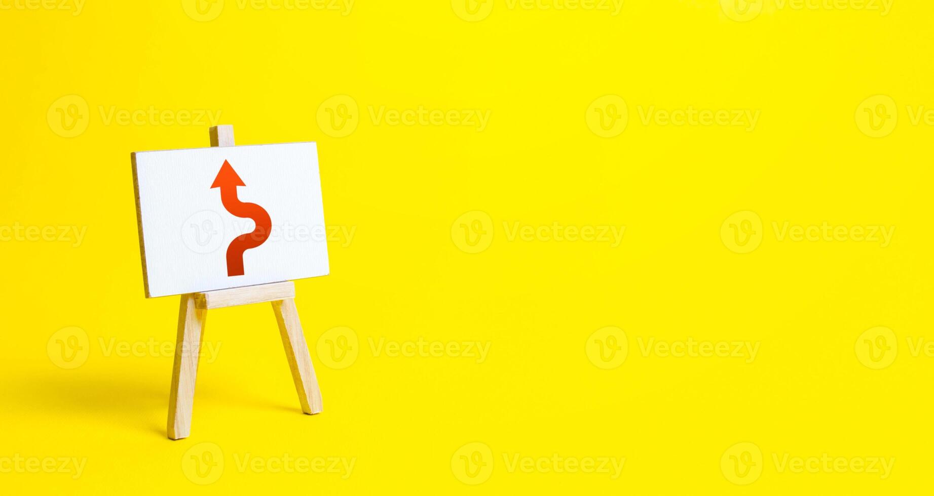 An easel with a red arrow avoiding an obstacle. Deviation from the route, side mission. Purposefulness and perseverance, confident movement towards the assigned goal. Maneuvering, taking right action. photo