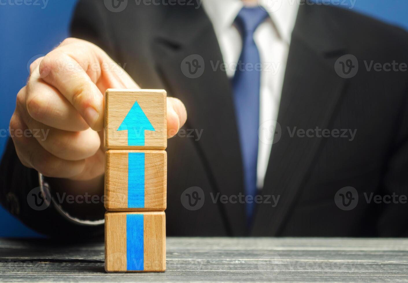 Businessman builds a tower of blocks with an up arrow. Career promotion , growth of professional skills. Business development, expansion improvement. Profit growth. Marketing. Improving efficiency photo