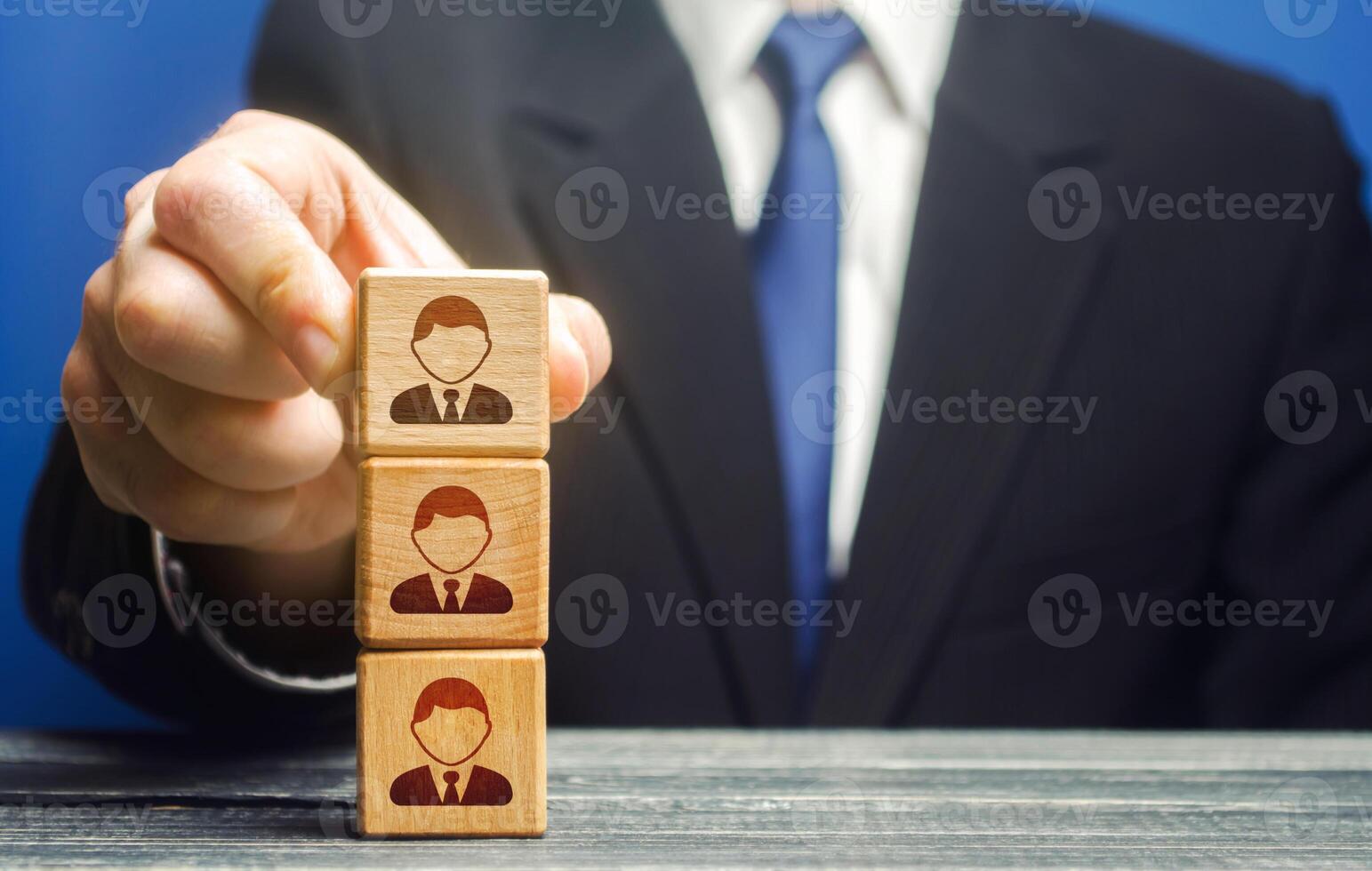 Business leader builds a tower block with employees. Team building, hierarchical power vertical system. Leadership. Effective team Management. Company organization. Hiring and recruiting workers photo