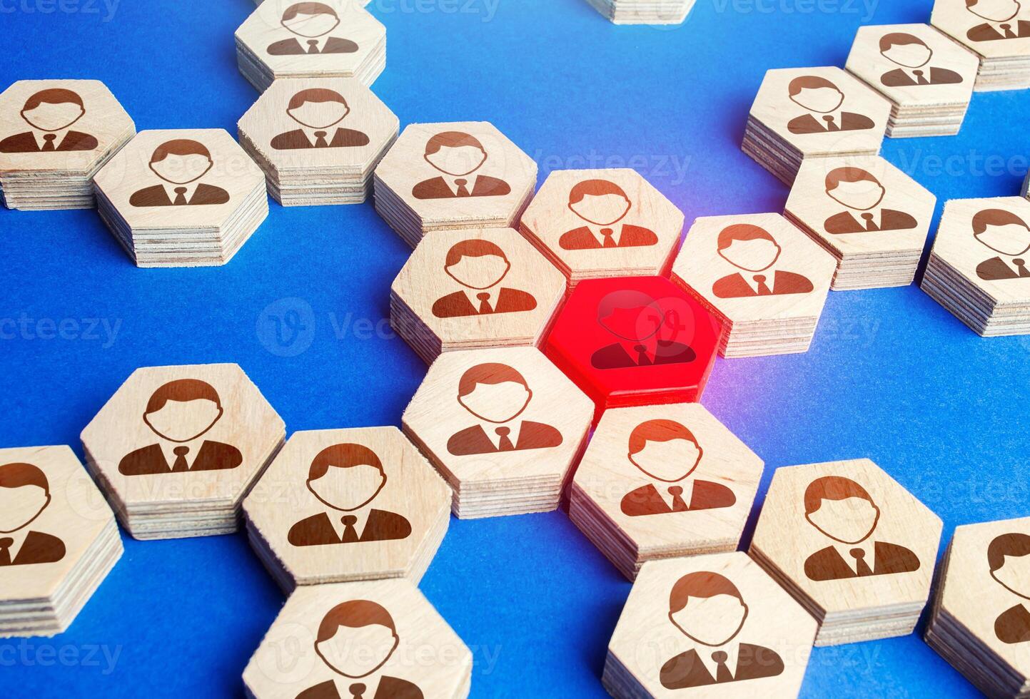 Red figurine of an employee in a big business company structure. Toxic and unreliable worker, bad influence. Leadership, teamwork. Staff relationships. Founder of the company, uniting around idea. photo