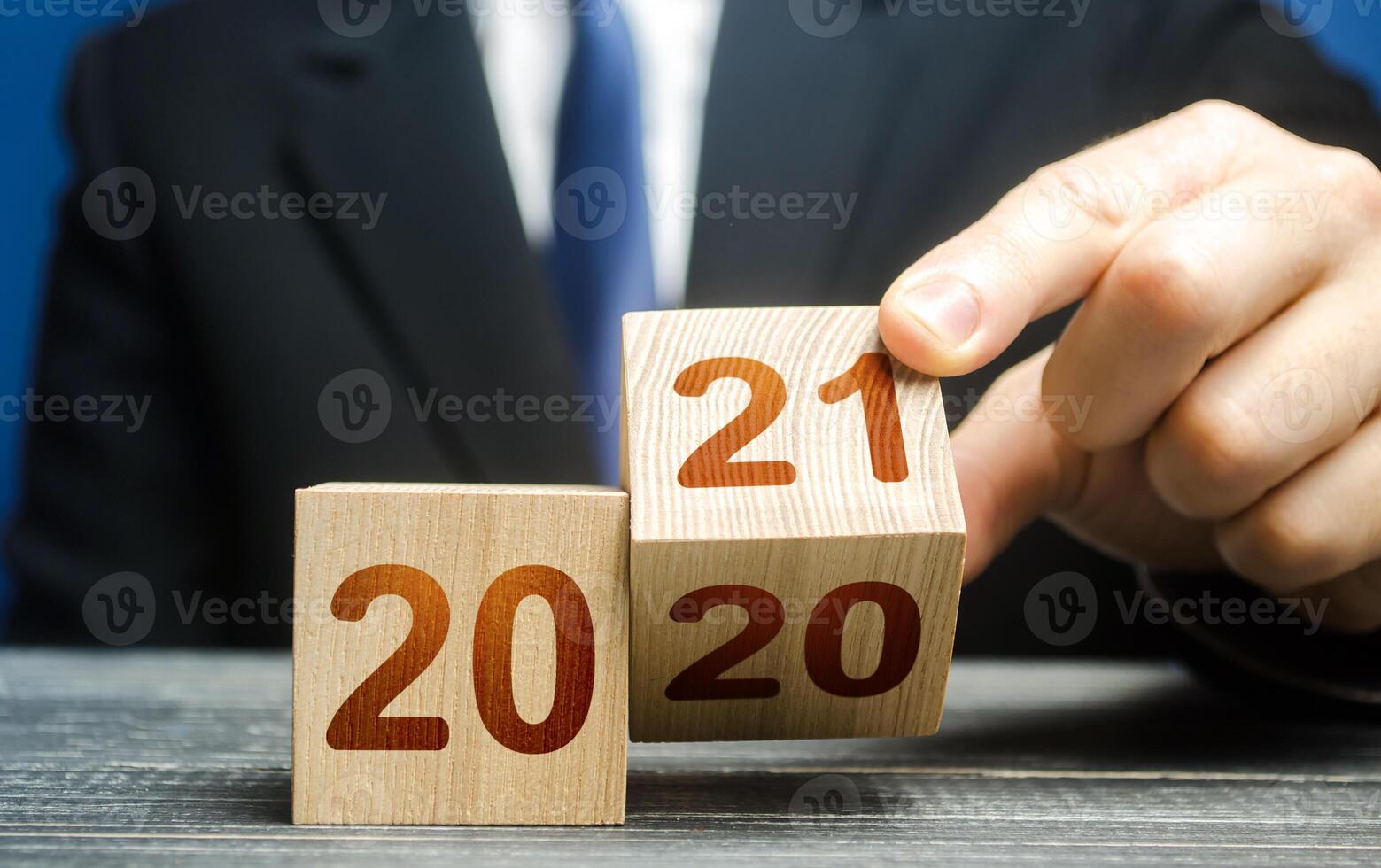 Hand flips a block changing 2020 to 2021. New year beginning. Holidays and Christmas. Trends and changes in the World. Summing work done. Keep up with everything planned. Build plans. New normal. photo