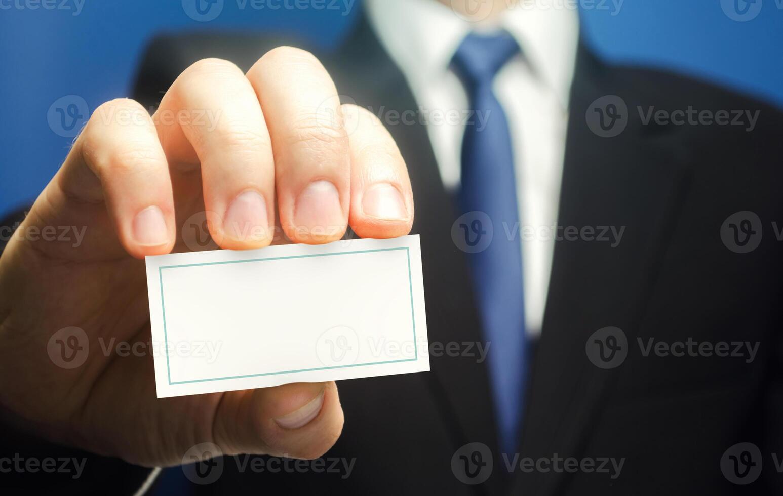 Businessman introduces himself with a business card. Presentation, hands over contacts to client. Agent offers his services. Solidity and style. Business advertising. Attracting new customers buyers. photo