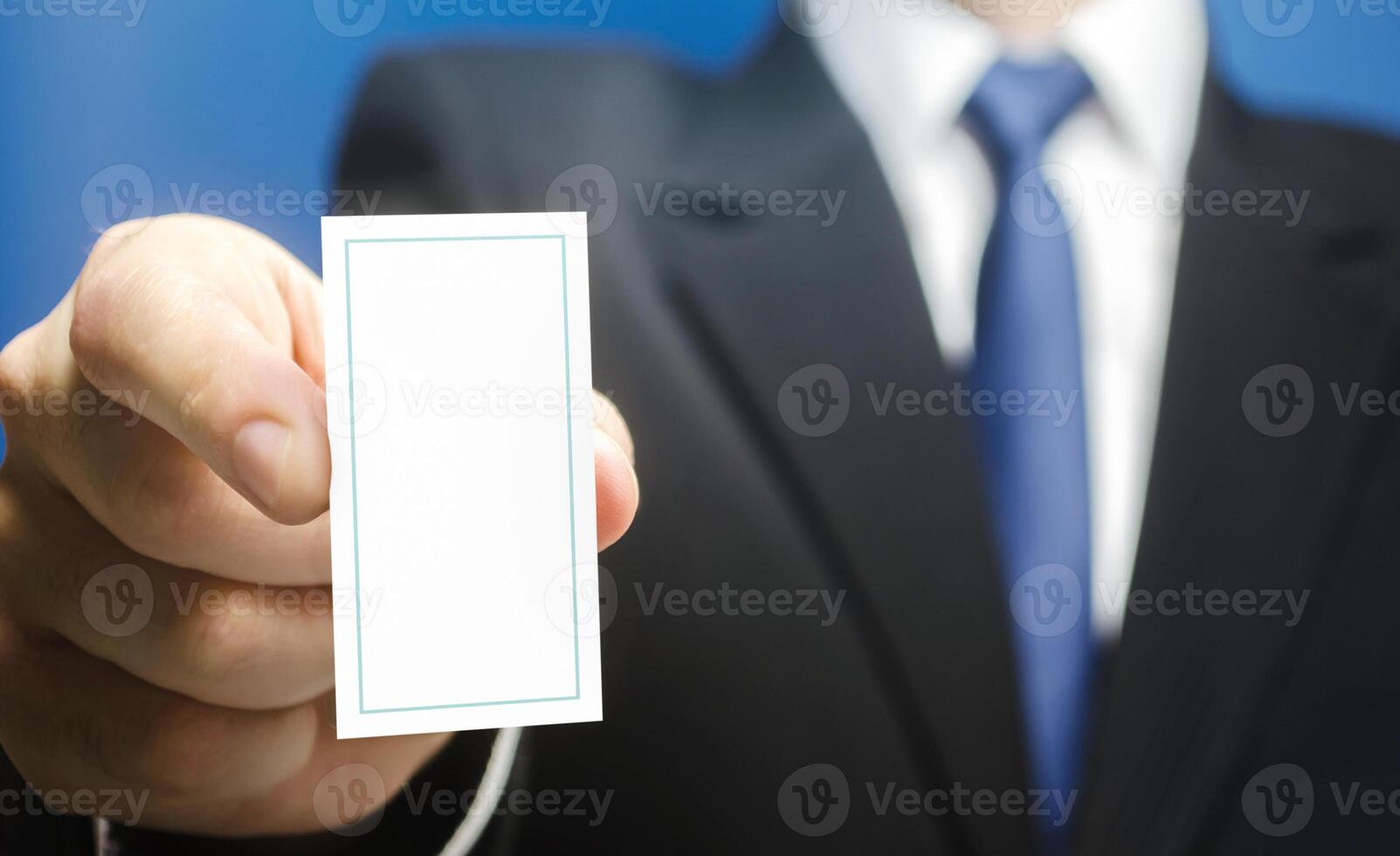 Businessman introduces himself with a vertical business card. Presentation, hands over contacts to client. Business advertising. Attracting new customers. Agent offers his services. Solidity and style photo
