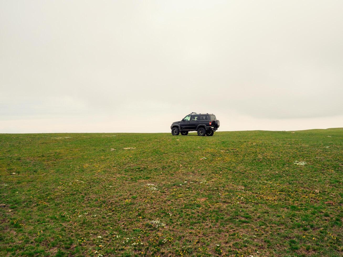 Russia. Dagestan. Hunzah. May 2021 Off-road Uaz patriot vehicle on the edge of a steep cliff. Eagle photo