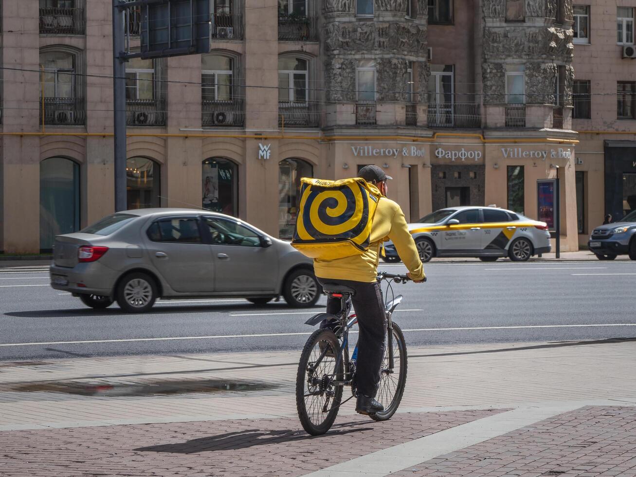 Moscow - July 31,2020 Food delivery. A cyclist delivers food on Kutuzovsky prospect in Moscow photo