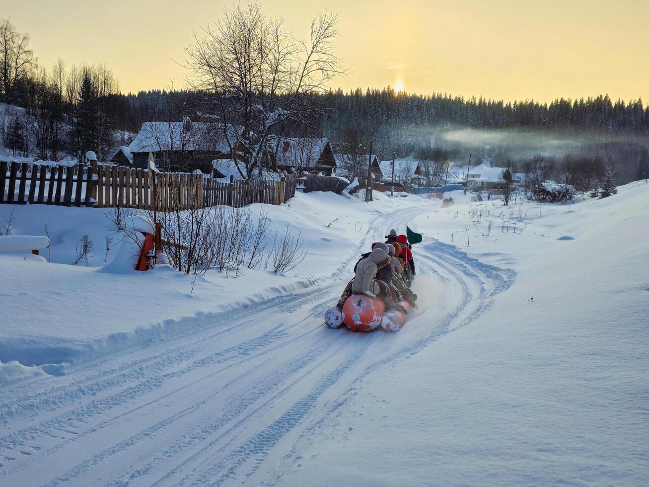 Perm Region, Russia - January, 05, 2024 People sit on an inflatable banana for skiing in winter. Perm region photo