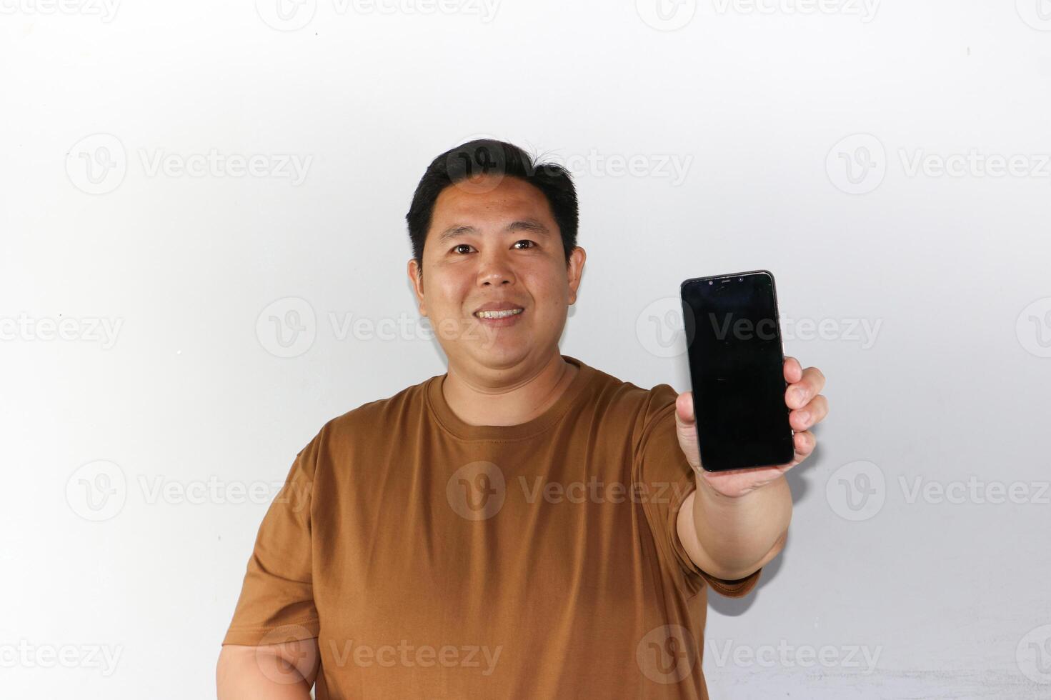 Cheerful face A man while showing his blank screen of smartphone over isolated white. photo