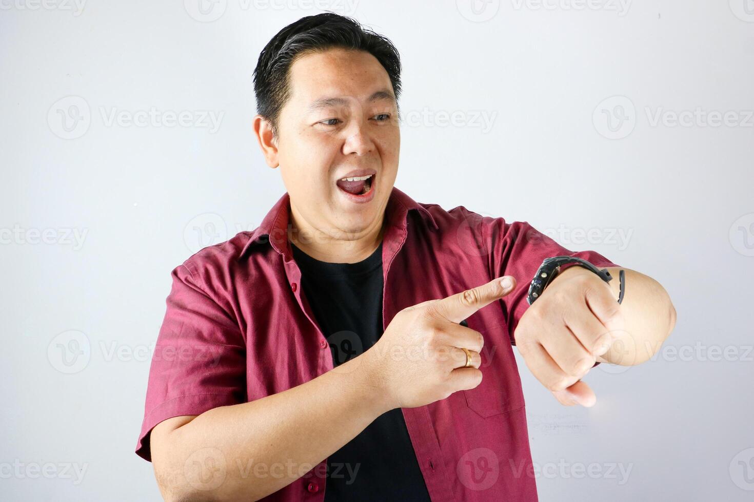 Happy face expression and excited gesture of handsome man pointing his finger to his watch for being on time in important appointment or meeting. photo