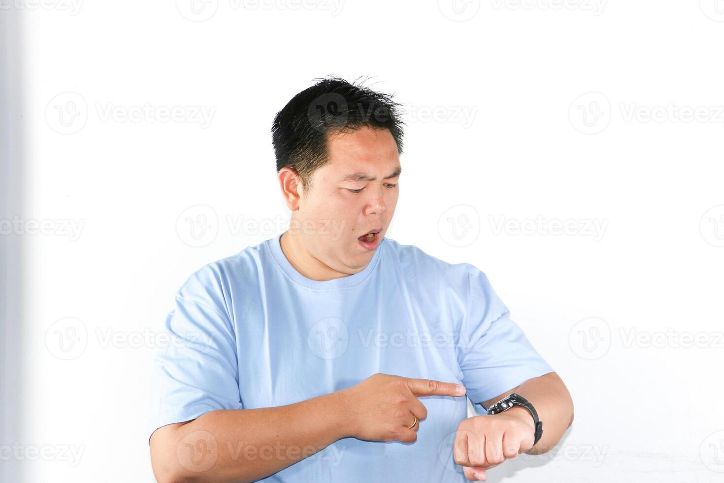 Unhappy face expression and angry gesture of Asian man pointing his finger to his watch for being on time in important appointment or meeting. photo
