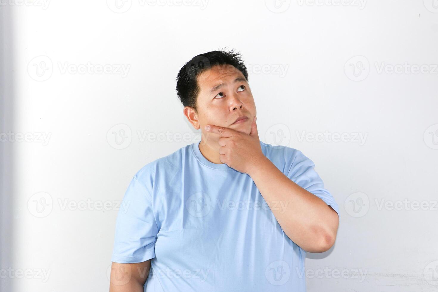 Serious expression of thoughtful A man holding his chin and thinking and consider something. photo