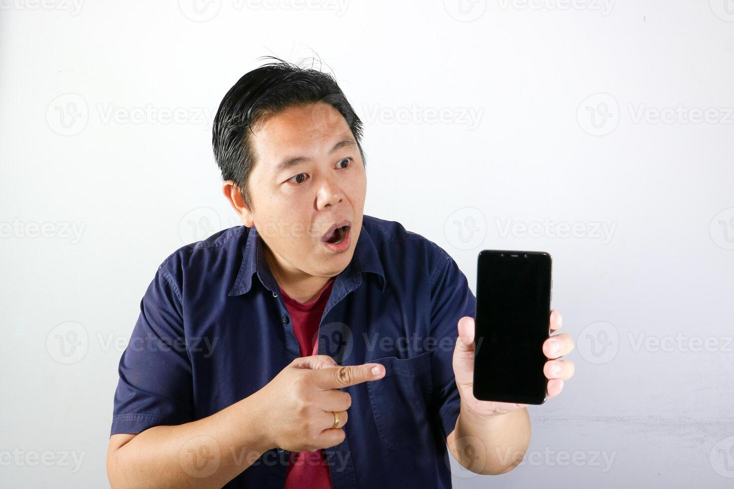 Shocked, surprised and wow expression of handsome Man using his smartphone over isolated white background. photo