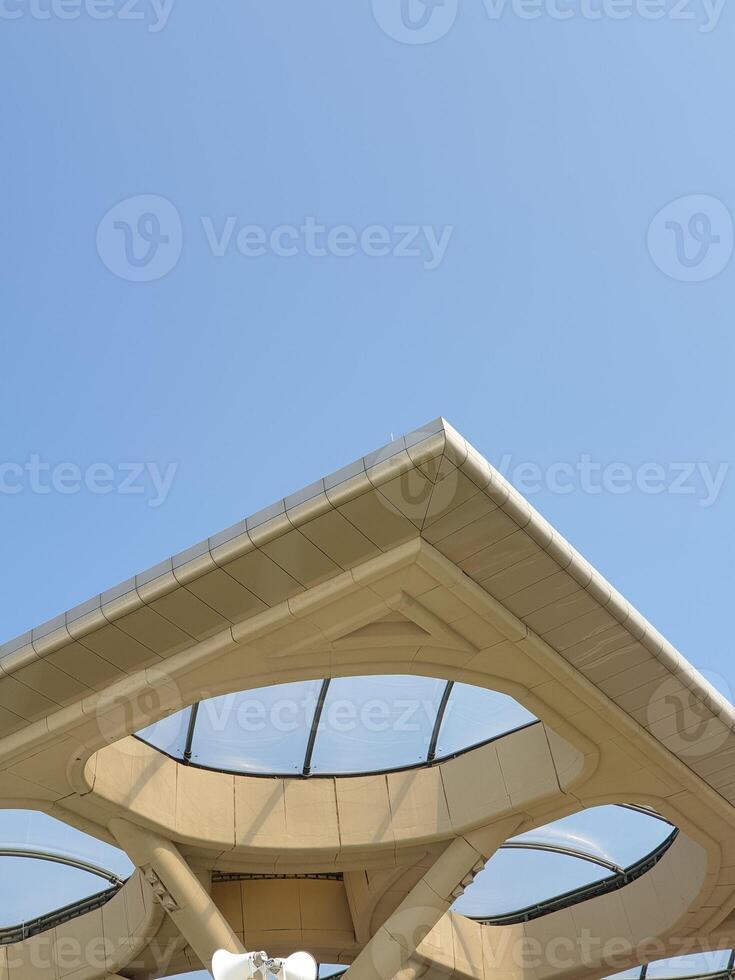 Architectural detail of a modern building with large glass windows against a blue sky photo