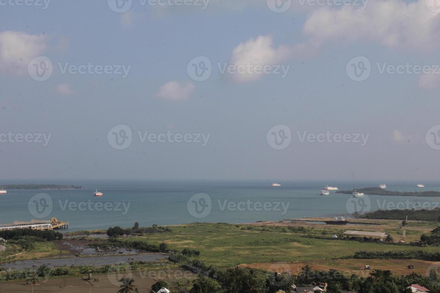 Panoramic Seascape with Ships and Coastal Vegetation Under a Blue Sky With Clouds photo