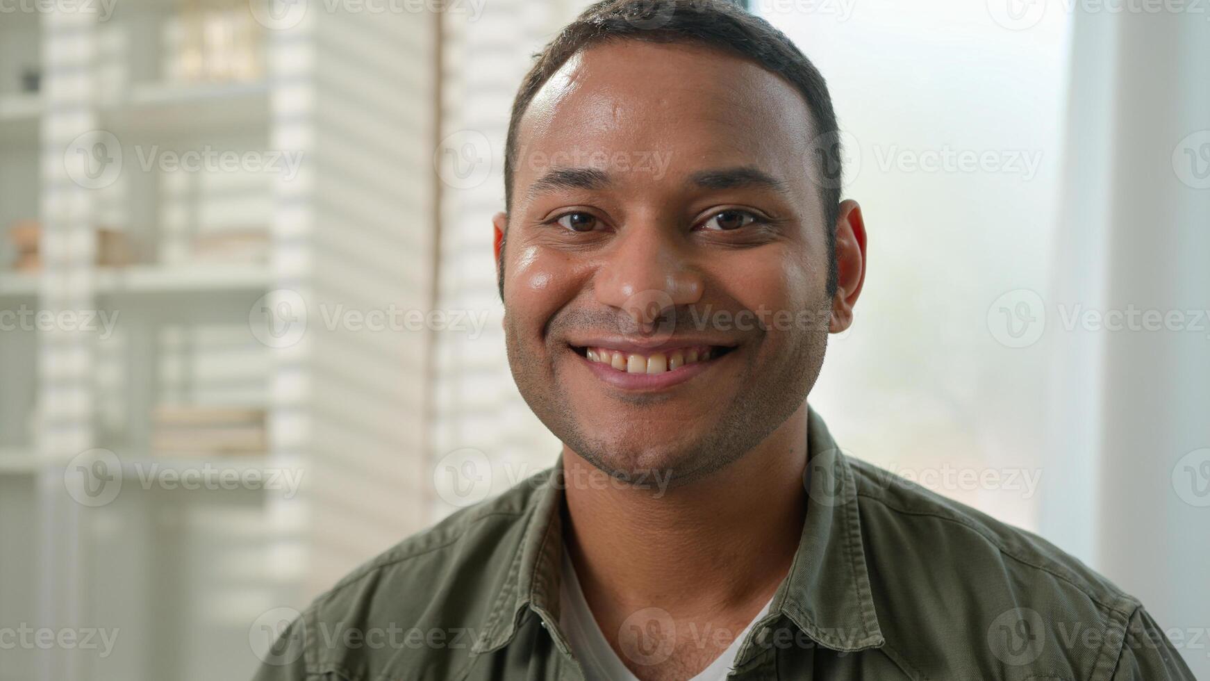 Portrait smiling Indian latin American man happy millennial single guy homeowner in living room relax at home office male businessman renter own estate apartment looking at camera toothy smile at home photo