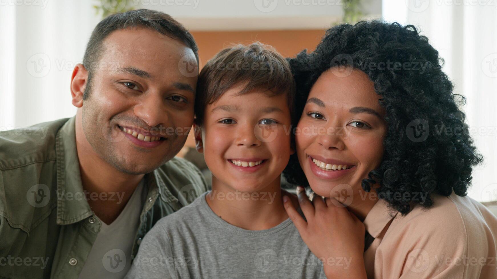 Happy multiracial African American loving mum and dad kissing little boy in cheeks adoption child care family bonding caring parents hug cuddle embrace little kid son love relationship affectionate photo