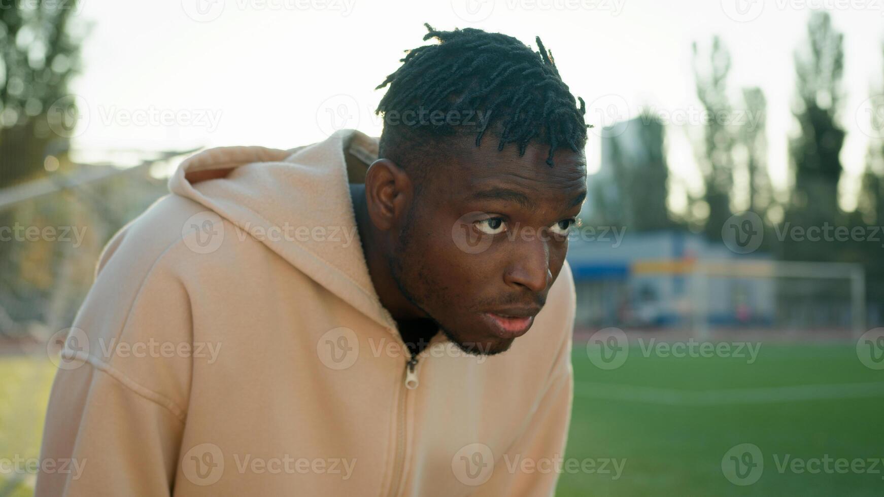 African American sport man heavy breathing sweating stop morning workout on city stadium outdoors tired exhausted face sportsman athlete hard breathe fatigue rest after running exercise break pause photo