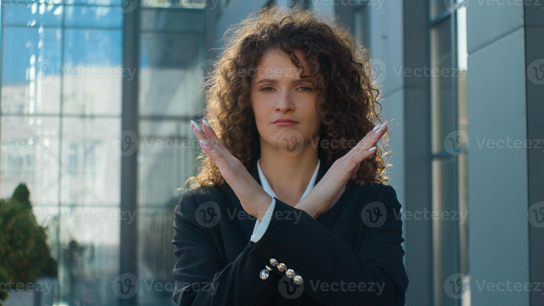 Caucasian serious confident woman business girl female businesswoman showing stop gesture at camera crossed hands never no not sign crossing arms negative attitude forbid reject deny in city outdoors photo