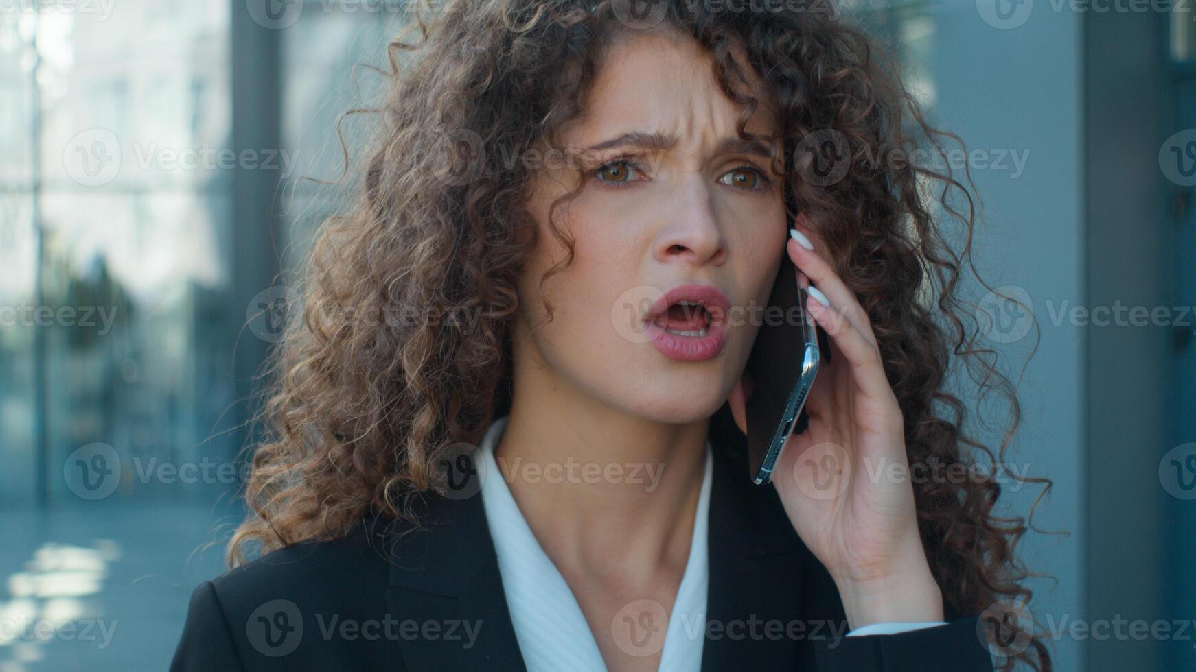 Aggressive angry mad business woman Caucasian businesswoman annoyed female girl boss walk go on city street talking mobile phone smartphone conversation quarrel conflict negative emotions irritated photo