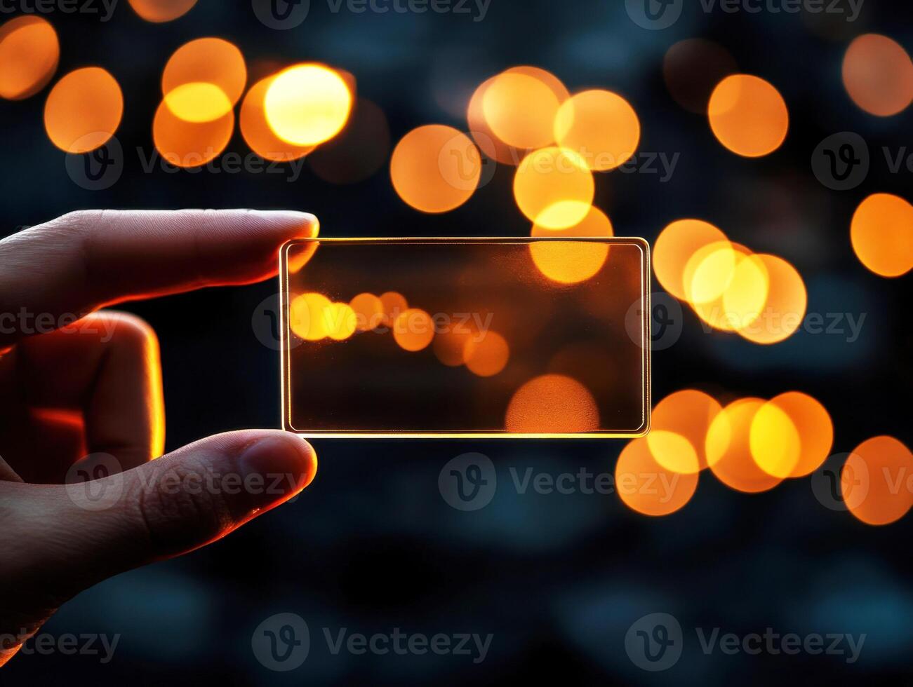 Capturing light through a transparent card with a backdrop of glowing bokeh lights at night photo