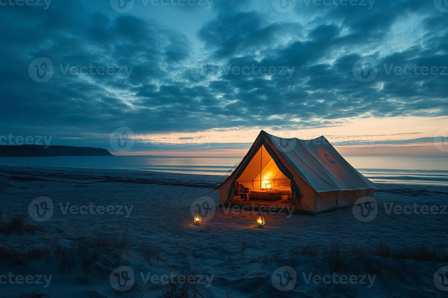 Illuminated tent embraces the tranquil beach at twilight, creating a serene coastal camping scene photo