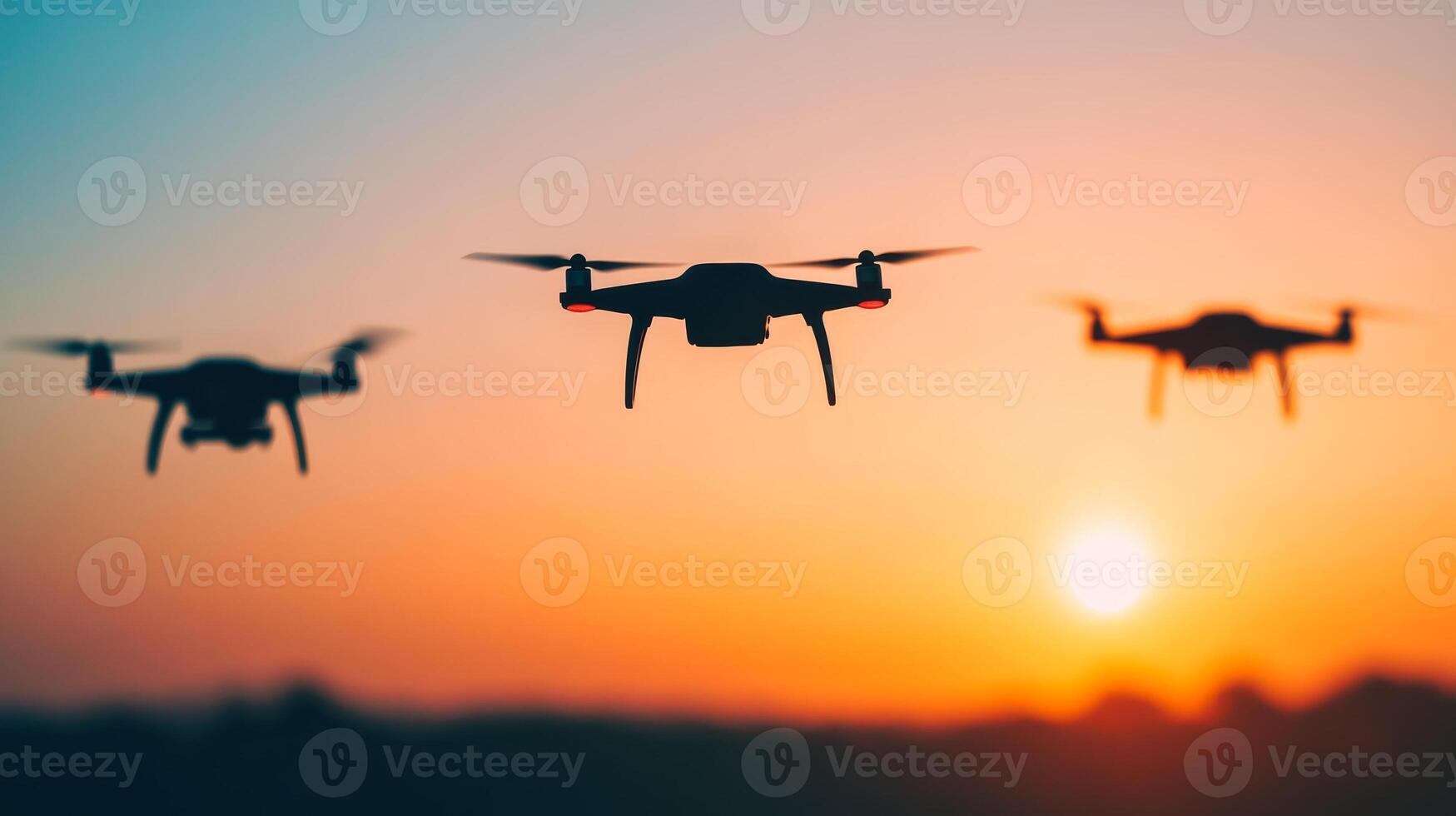 Drones fly against a colorful sunset over a landscape, capturing stunning aerial views and creating a dramatic silhouette effect photo